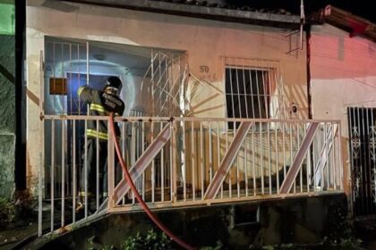 imagem da casa e bombeiros tentando apagar o incêndio